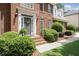 Inviting brick front porch with meticulously maintained bushes and a grey front door at 1915 Milfield Cir, Snellville, GA 30078