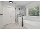 Stylish bathroom complete with frameless shower, soaking tub, and marble-look tile at 2350 Twelvestones Dr, Roswell, GA 30076