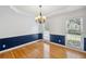 Bright dining room featuring hardwood floors, wainscoting, and a decorative chandelier at 2350 Twelvestones Dr, Roswell, GA 30076