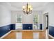 Sunlit dining room featuring hardwood floors, wainscoting, and two large windows at 2350 Twelvestones Dr, Roswell, GA 30076