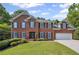 Charming two-story brick home with a well-manicured lawn, complemented by dark shutters at 2350 Twelvestones Dr, Roswell, GA 30076
