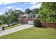 A two-story brick home with a long driveway, garage, and lush green lawn at 2350 Twelvestones Dr, Roswell, GA 30076