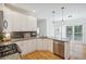 Bright kitchen with white cabinets, stainless steel appliances, granite countertops and hardwood floors at 2350 Twelvestones Dr, Roswell, GA 30076