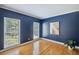 Living room with hardwood floors, and two bright windows and a painted accent wall at 2350 Twelvestones Dr, Roswell, GA 30076