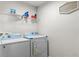 A well-lit laundry room with washer, dryer, and shelving for storage at 26 Springbottom Dr, Lawrenceville, GA 30046