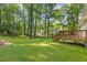 Expansive backyard featuring a wooden deck, lush lawn, and mature trees providing ample shade at 2856 Bay Leaf Se Dr, Conyers, GA 30094