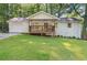 Charming ranch-style home with a covered front porch and attached garage, surrounded by lush greenery and mature trees at 2856 Bay Leaf Se Dr, Conyers, GA 30094