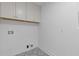 Compact laundry room with overhead cabinets, patterned tile floor and white walls at 2856 Bay Leaf Se Dr, Conyers, GA 30094