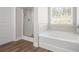 Bathroom featuring a tub, shower, and window that lets in natural light over a modern floor at 33 N Village Cir, Rydal, GA 30171