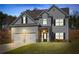 Charming two-story home with gray siding, black shutters, two-car garage, and well-manicured lawn at 33 N Village Cir, Rydal, GA 30171