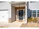 Welcoming front entrance features a stylish door with glass panels and decorative brick accents at 33 N Village Cir, Rydal, GA 30171