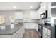 Bright kitchen featuring white cabinets, stainless steel appliances, and granite countertops at 33 N Village Cir, Rydal, GA 30171