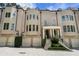 Elegant brick townhome featuring multiple garage spaces, arched windows, and a welcoming front porch with stately columns at 122 Old Ivy Ne Rd # 17, Atlanta, GA 30342