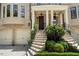 A detailed view of the home's entrance, showcasing manicured landscaping, an elegant staircase, and a covered porch at 122 Old Ivy Ne Rd # 17, Atlanta, GA 30342