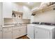 Well-equipped laundry room with white cabinets, granite countertops, sink, and washer/dryer at 122 Old Ivy Ne Rd # 17, Atlanta, GA 30342