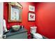 Bright powder room boasts bold red walls, unique bowl sink, and ornate gold-framed mirror at 122 Old Ivy Ne Rd # 17, Atlanta, GA 30342