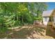 Serene backyard featuring mature trees, lush greenery, and a wooden deck, creating a private oasis for outdoor enjoyment at 1921 Flint Hill Dr, Lawrenceville, GA 30044