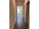 Hallway with wood flooring leading to a room with neutral walls at 3706 Cheswolde Ave # 96, Powder Springs, GA 30127
