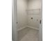 Tiled laundry room with wire shelving, light walls, and electrical outlets at 3706 Cheswolde Ave # 96, Powder Springs, GA 30127