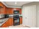 The kitchen has wooden cabinetry and black appliances and countertops at 721 Beaufort Cir, Duluth, GA 30096