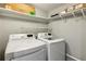 Laundry room with white washer and dryer and storage shelves at 721 Beaufort Cir, Duluth, GA 30096