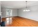 Expansive living room with hardwood floors, a chandelier, and sliding doors to the porch for relaxing at 721 Beaufort Cir, Duluth, GA 30096