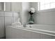 Clean bathroom featuring a tiled tub, white cabinets and a decorative vase with fresh flowers, creating a spa-like atmosphere at 78 Crumley Se St, Atlanta, GA 30312