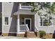 Charming home exterior with a black front door, hanging plants, and brick steps at 78 Crumley Se St, Atlanta, GA 30312