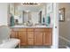 Double sink bathroom featuring wooden cabinets and a large mirror at 102 Autumn Brooke Trl, Dallas, GA 30157