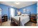 Comfortable bedroom featuring wood floors, nautical decor, a large window, and blue painted walls at 102 Autumn Brooke Trl, Dallas, GA 30157