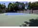 This tennis court features a blue surface, a net, and benches at 1606 Parkaire Xing # 1606, Marietta, GA 30068