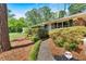 Charming brick home with lush landscaping and a covered entrance, with a brick walkway leading to the front door at 561 Sybil Se Ln, Marietta, GA 30067