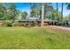 Charming brick home with lush landscaping and a covered carport nestled among mature trees on a well-manicured lawn at 561 Sybil Se Ln, Marietta, GA 30067