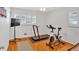 Home gym with hard wood floors, a treadmill and elliptical machine in a bright room with two windows at 561 Sybil Se Ln, Marietta, GA 30067