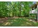 Large backyard with mature trees and a covered patio for relaxing at 7401 Cherry Blossom Way, Winston, GA 30187