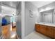 Bright bathroom featuring a wood vanity and a large mirror, adjacent to a cute bedroom at 7401 Cherry Blossom Way, Winston, GA 30187