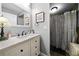 Stylish bathroom featuring a decorative mirror, soft lighting, and a shower with a patterned curtain at 7401 Cherry Blossom Way, Winston, GA 30187