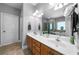 Bright bathroom featuring a double sink vanity with wood cabinets and a large mirror at 7401 Cherry Blossom Way, Winston, GA 30187