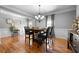 Elegant dining room with hardwood floors, detailed molding, and a modern chandelier at 7401 Cherry Blossom Way, Winston, GA 30187