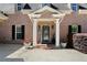 Charming front entrance with a decorated door, black shutters and decorative plants in pots at 7401 Cherry Blossom Way, Winston, GA 30187