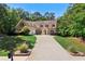 Charming brick home featuring a long driveway, well-manicured lawn, and mature trees at 7401 Cherry Blossom Way, Winston, GA 30187