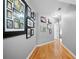 Hallway with beautiful hardwood floors and a wall decorated with framed Gathering photos at 7401 Cherry Blossom Way, Winston, GA 30187