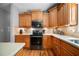 Charming kitchen with wooden cabinetry, updated appliances, and a tiled backsplash at 7401 Cherry Blossom Way, Winston, GA 30187