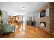 Inviting living room featuring a brick fireplace, hardwood floors, and lots of light at 7401 Cherry Blossom Way, Winston, GA 30187