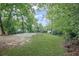 Large, grassy backyard featuring mature trees, parking, and concrete slab at 1591 Jonesboro Se Rd, Atlanta, GA 30315
