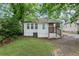 Back exterior view of this charming home with a grassy yard and shaded by mature trees at 1591 Jonesboro Se Rd, Atlanta, GA 30315
