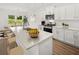 Modern kitchen features white cabinets, stainless steel appliances, an island with seating, and hardwood floors at 206 Sharon Ln, Loganville, GA 30052