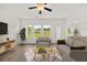 Bright living room with large windows, neutral decor, and open floor plan to the kitchen and dining area at 206 Sharon Ln, Loganville, GA 30052