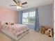 Bright bedroom with a large window, light blue walls, and a ceiling fan at 3825 Sycamore Hill Dr, Loganville, GA 30052