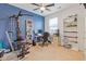 Bright bedroom with blue walls, ceiling fan, a desk, bookshelves, and carpet at 3825 Sycamore Hill Dr, Loganville, GA 30052